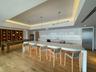 Kitchen featuring a kitchen breakfast bar, a tray ceiling, light wood-type flooring, stainless steel appliances, and pendant lighting