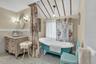 Full bathroom featuring a freestanding soaker tub, tile walls, lofted ceiling, vanity
