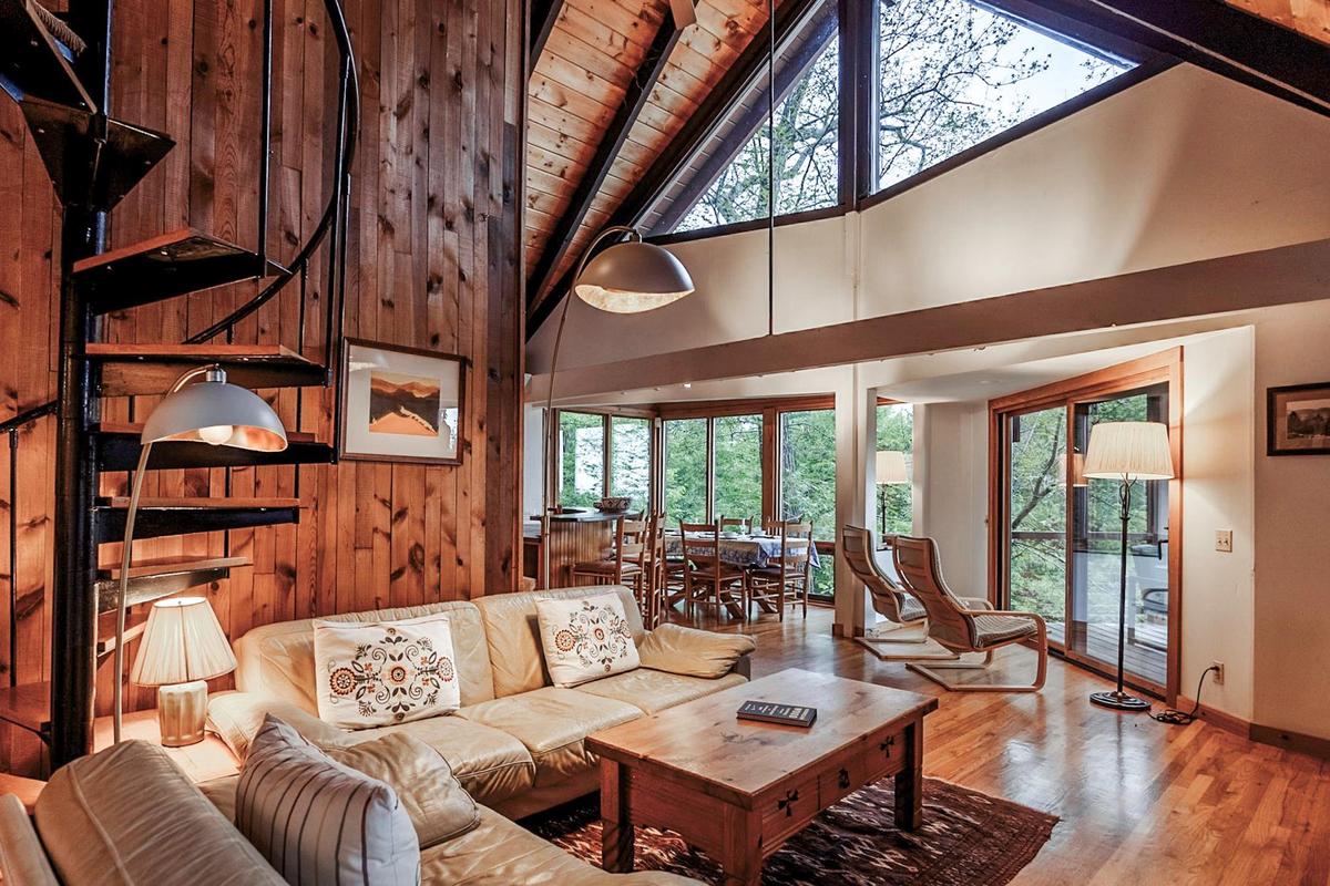 Living room featuring a wealth of natural light, high vaulted ceiling, wood finished floors, and beamed ceiling