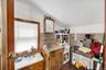 Kitchen featuring brown cabinets, tile walls, light countertops, vaulted ceiling, and wainscoting