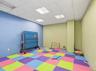 Recreational room featuring colorful interlocking floor mats and a drop ceiling with integrated lighting
