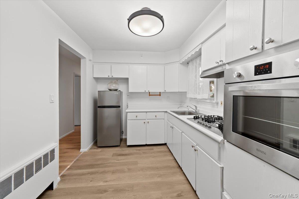 Kitchen with window over sink, new appliances, new luxury vinyl flooring and freshly painted.