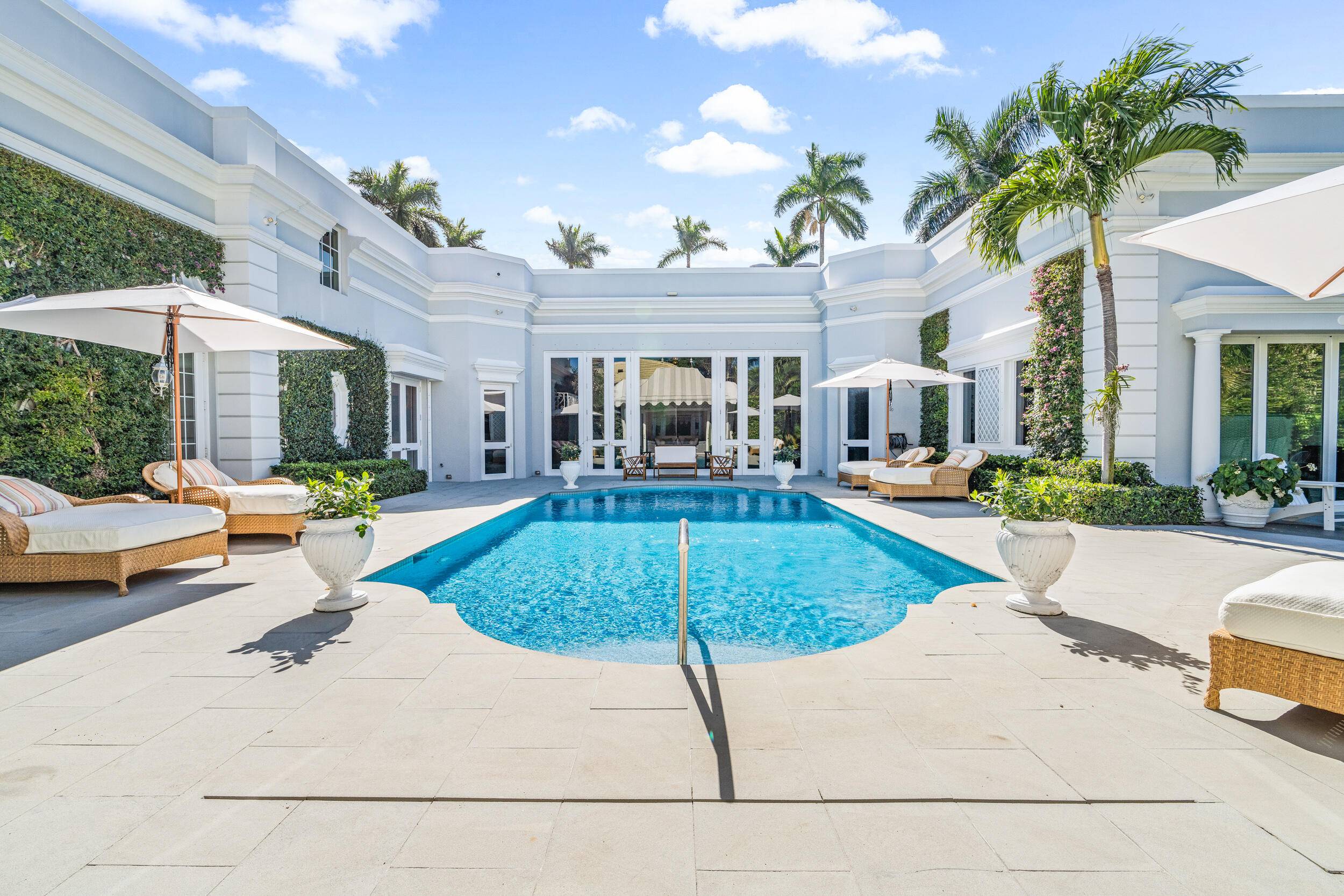 Regally elevated on over half acre this very proper Palm Beach residence showcases quintessential Palladian architecture set within beautifully landscaped pool gardens.