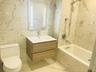 Full bathroom featuring tiled shower / bath combo, vanity, tile walls, and toilet