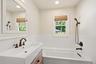 Soaking tub and window offering natural light.