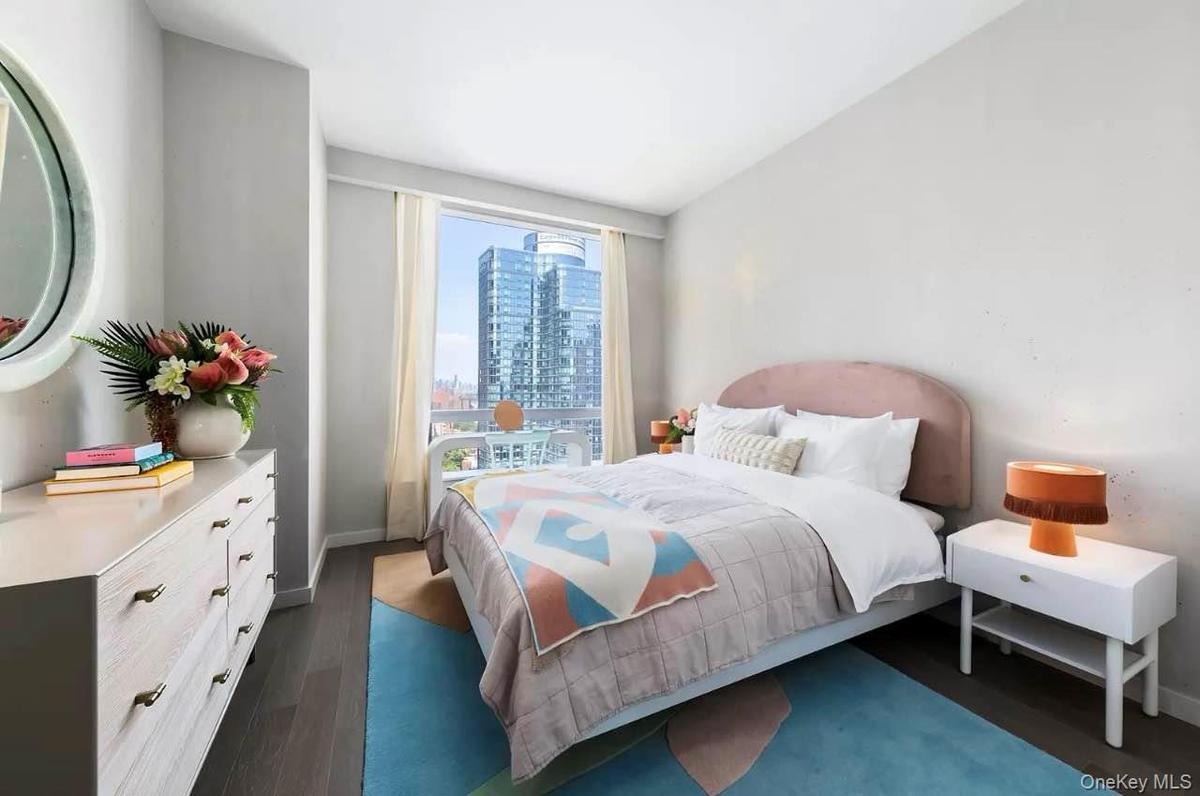 Bedroom with a view of city and dark wood finished floors