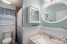 Full bath with vanity, a shower with shower curtain, and wainscoting
