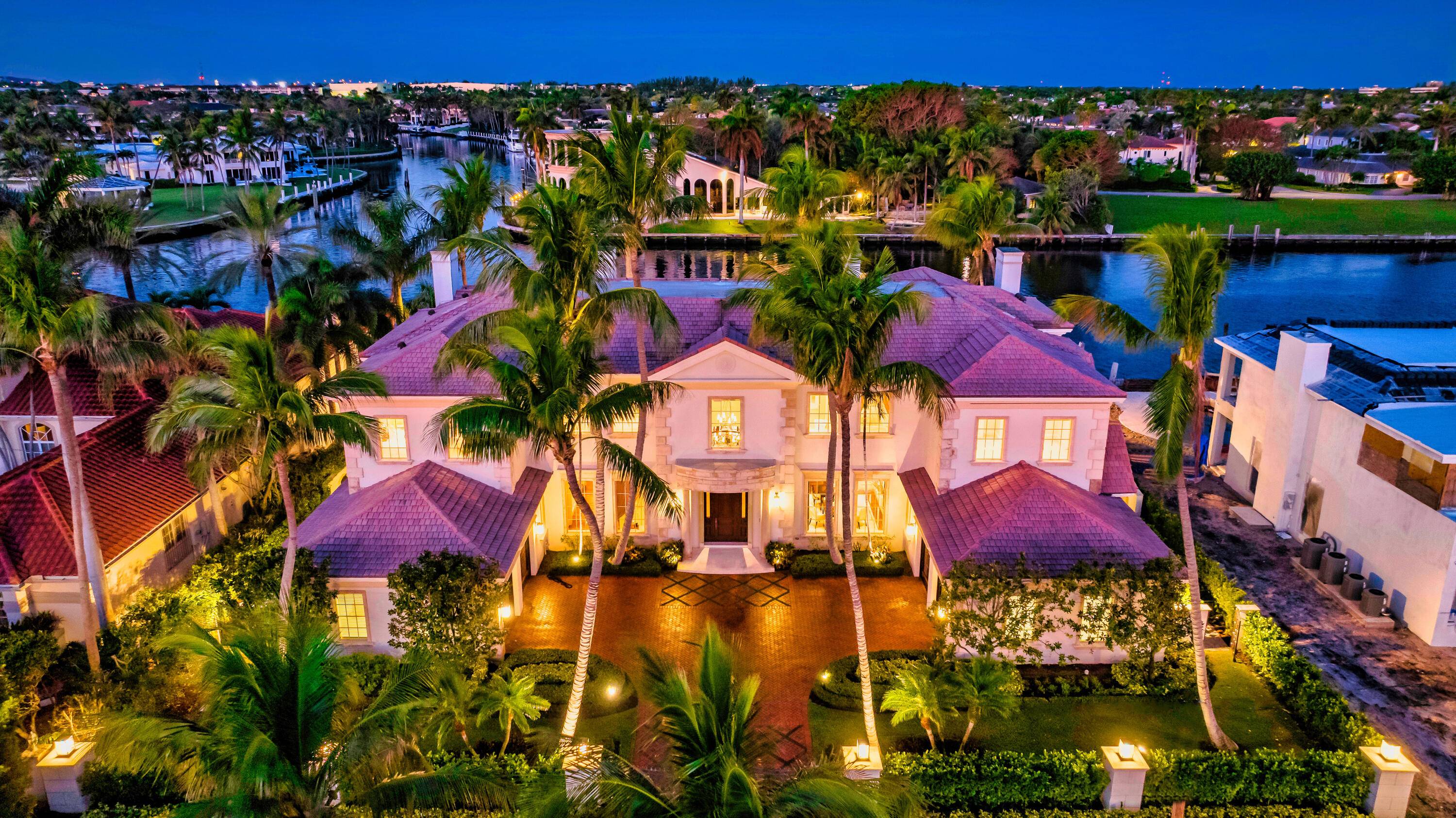 Gated Palm Beach inspired Tropical Georgian sited on 123 feet of Intracoastal with wide views overlooking Royal Palm's Grand Canal and originally built by acclaimed Frankel Estate Homes, Carlos Martin ...