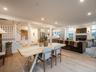 Dining area featuring a tile fireplace, stairs, light wood finished floors, and recessed lighting