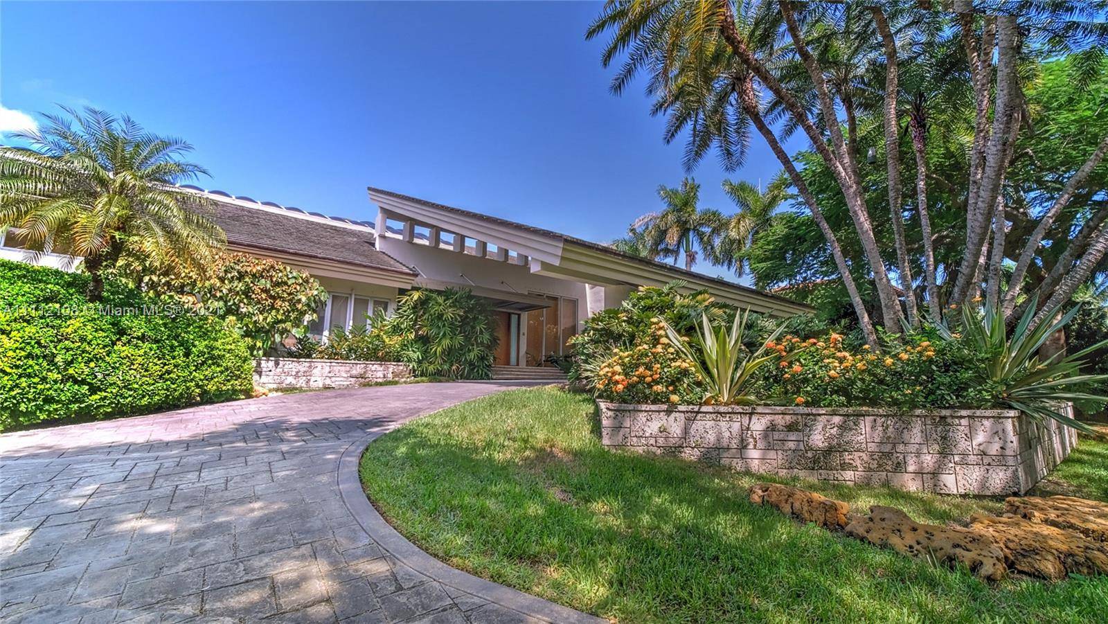 Fabulous Miami Modern waterfront home in glamorous, gated Gables Estates boasts grandly scaled dbl height interiors and cascading natural light.