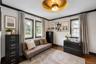 Interior space featuring dark wood-finish flooring, light grey walls with contrasting dark trim, and multiple windows providing natural illumination