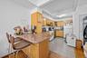 Kitchen with a kitchen breakfast bar, open shelves, light wood-style floors, white appliances, and a peninsula
