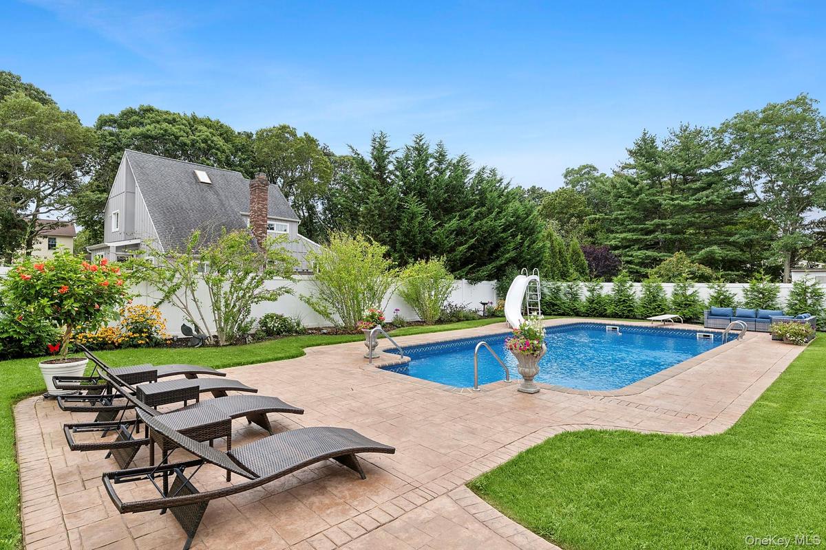 View of swimming pool featuring a patio area, a fenced backyard, and a water slide