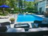 Outdoor pool with an outdoor living space, a wooden deck, a patio, and view of scattered trees