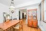 Dining area featuring wood-finish flooring, a decorative overhead light fixture, and a window with wood trim