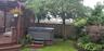 View of yard with a pergola, fence, a wooden deck, and a hot tub