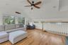 Living room with ceiling fan, vaulted ceiling, and light wood-style floors