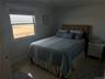 Bedroom featuring a water view, baseboards, and ornamental molding