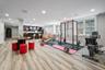 Exercise area with light wood finished floors, recessed lighting, and bar