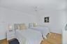 2nd floor twin bedroom featuring ceiling fan and television