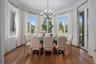 Dining room with ornamental molding, wood finished floors, and a chandelier
