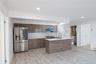 Kitchen with stainless steel appliances, light wood-type flooring, under cabinet range hood, modern cabinets, and recessed lighting