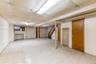 Finished basement featuring stairs, a paneled ceiling, and light floors