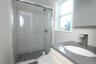 Bathroom featuring a subway tile shower with pebble flooring and clear glass enclosure