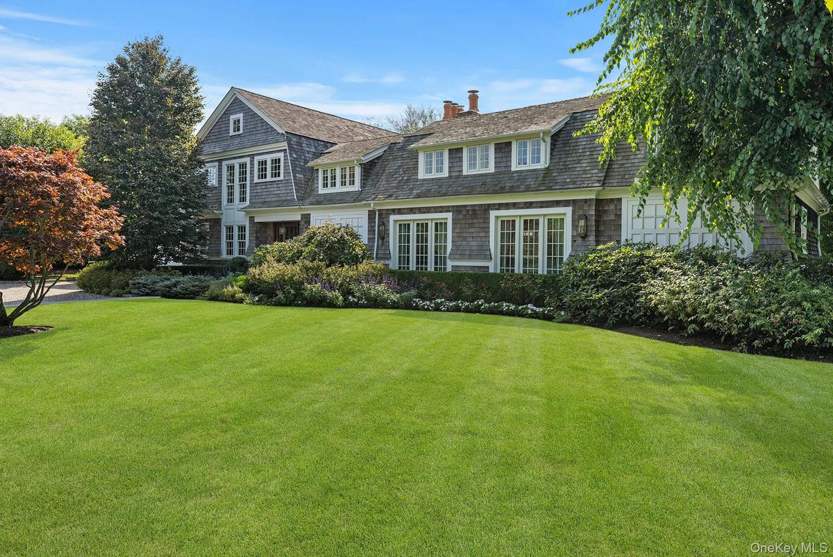 View of front of home with a chimney and a front lawn