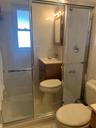 Full bathroom featuring vanity, tile walls, light tile patterned floors, and a shower stall
