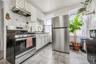 Kitchen with stainless steel appliances, decorative backsplash, under cabinet range hood, white cabinets, and light countertops