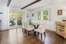 Dining room with dark wood-type flooring and beam ceiling