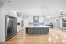 Kitchen with white cabinets, backsplash, stainless steel appliances, recessed lighting, and ornamental molding