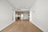 Unfurnished living room with light wood finished floors, stacked washer / dryer, and recessed lighting