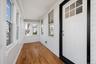 Unfurnished sunroom with wood finished floors, ornamental molding, and wooden walls