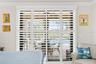 Primary Bedroom Featuring Sliding Glass Doors and Custom Shutters