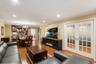 Open-concept living space featuring wood-finish flooring, recessed lighting, and crown molding