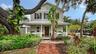 Beautifully landscaped Key West–inspired residence welcomes you with timeless architectural character, mature tropical landscaping, and an impressive