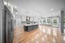 Kitchen featuring appliances with stainless steel finishes, white cabinets, tasteful backsplash, hanging light fixtures, and light wood-type flooring