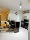 Kitchen with black appliances, white cabinetry, and dark countertops