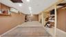 Finished below grade area featuring recessed lighting, a wall mounted air conditioner, baseboards, a paneled ceiling, and stairs