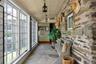 Striking enclosed breezeway with radiant-heated bluestone floors, exposed stone walls, and views across the central courtyard