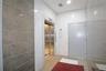 Corridor featuring elevator, tile walls, and recessed lighting