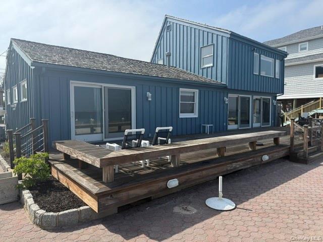 Back of house featuring a wooden deck and board and batten siding