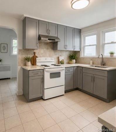 Kitchen featuring grey cabinetry, light countertops, and a tile backsplash
