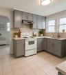 Kitchen featuring grey cabinetry, light countertops, and a tile backsplash