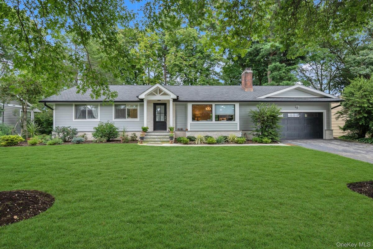 Single-story residence featuring light gray siding and a dark shingle roof