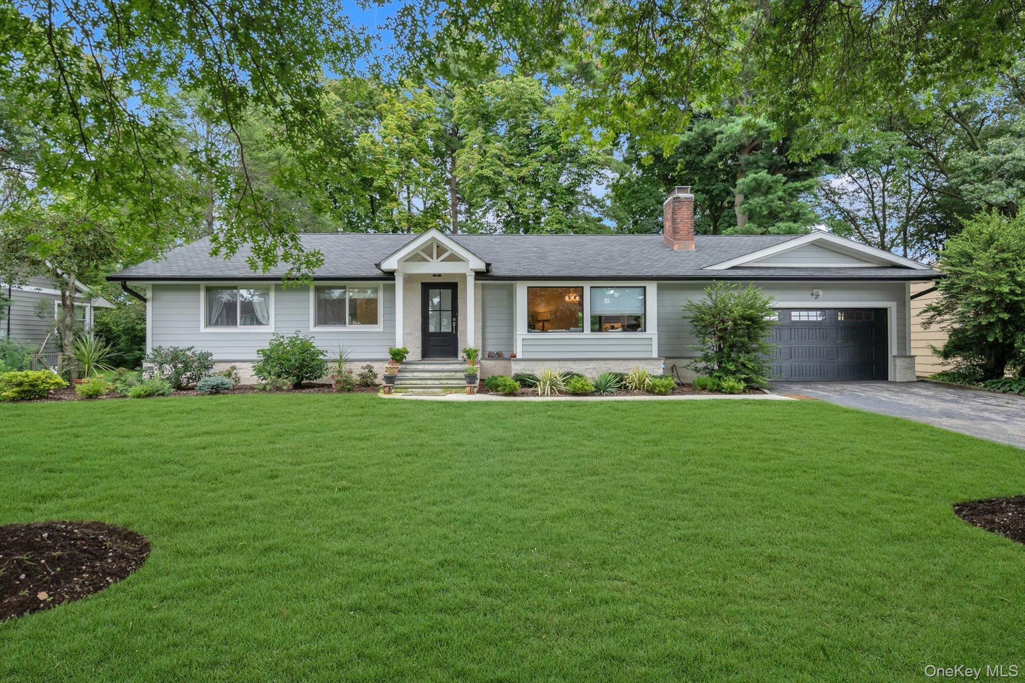 Single-story residence featuring light gray siding and a dark shingle roof