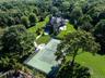Aerial view of property and surrounding area featuring a heavily wooded area