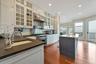Kitchen with sink, hanging light fixtures, a kitchen island with sink, high end range, and ornamental molding